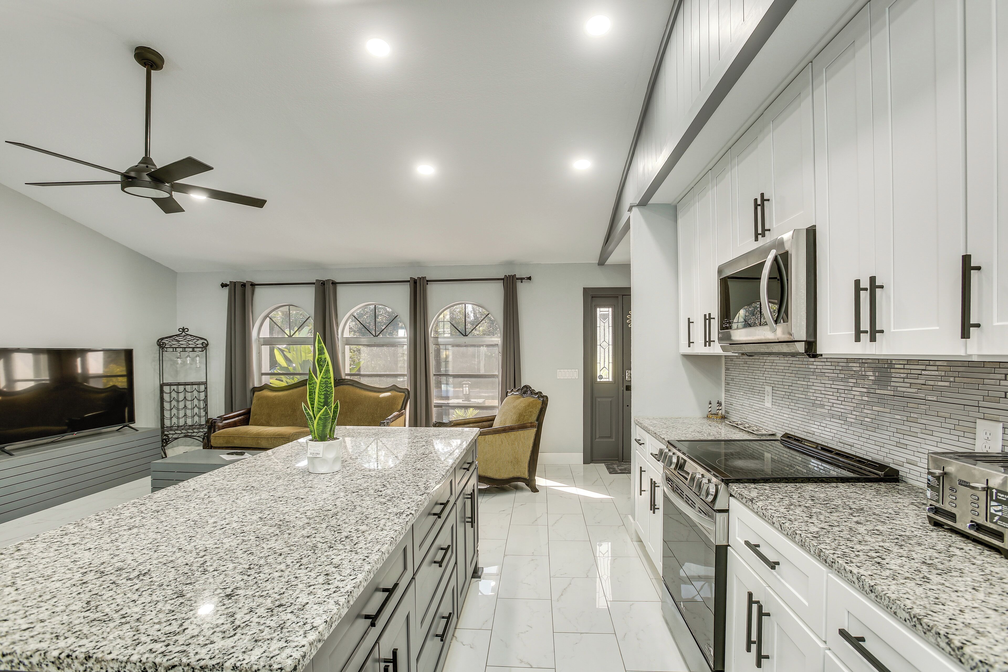 A modern kitchen with granite countertops, stainless steel appliances, and a large island.