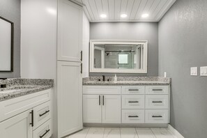 A bathroom with white cabinets, a granite countertop, and a large mirror above the sink. - Poolside Bliss! Port Charlotte Haven 4 Mi to Beach (Punta Gorda)