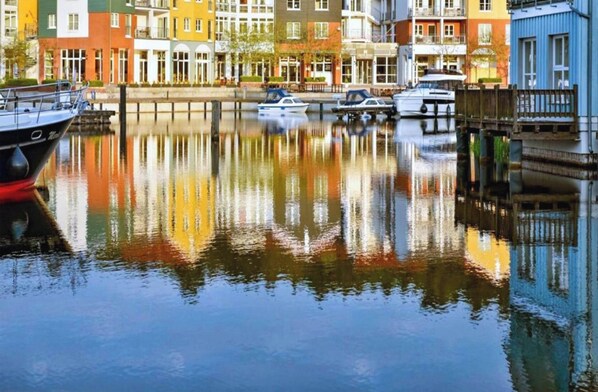 A canal with boats, colorful buildings, and a wooden bridge. - Sunday Resort Marina 1-bedroom Apartment (Rheinsberg)