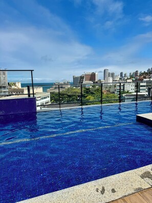 A rooftop infinity pool with a city view, surrounded by buildings and a clear sky. - Cozy NEW Apartment in Ondina   (Salvador)