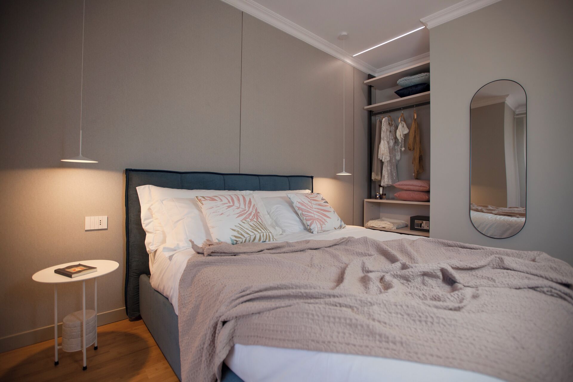 A modern bedroom with a bed, bedside table, and a built-in wardrobe.