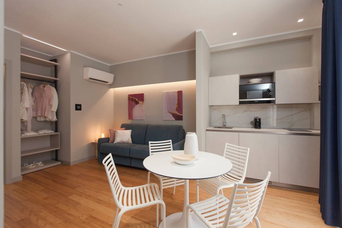 Un espacio habitable compacto con comedor, kitchenette y armario empotrado.