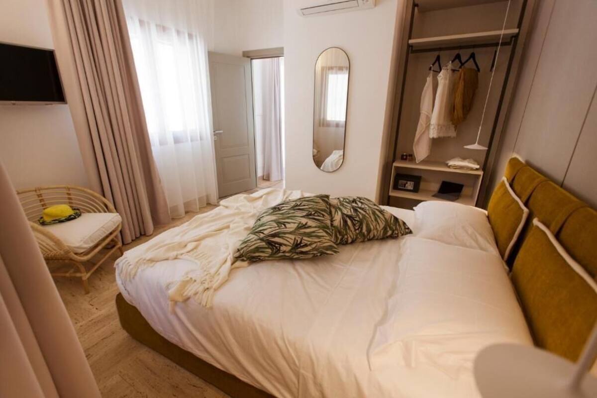 Una habitación de hotel con cama, armario, espejo y televisor.