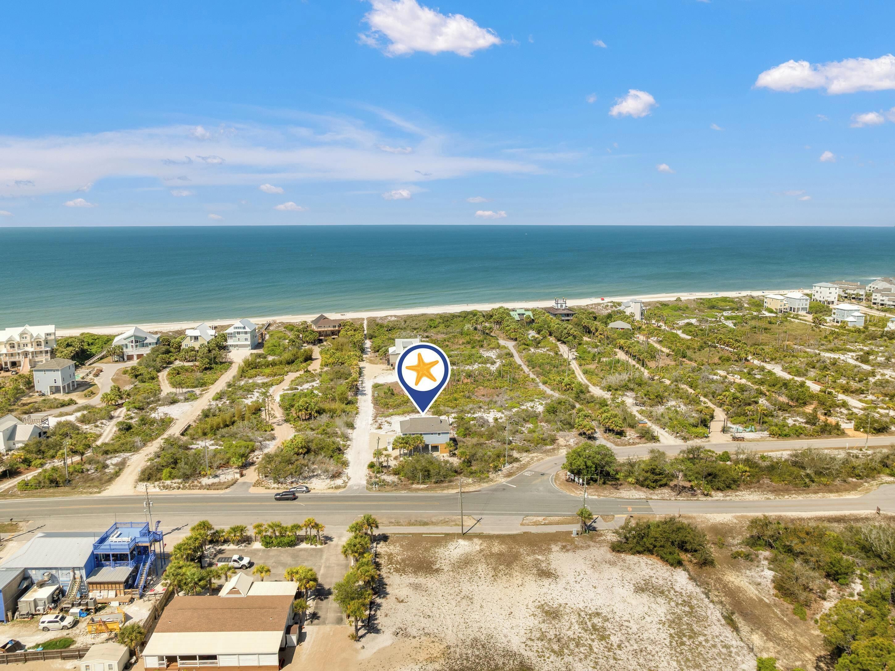 Vista aérea de una zona costera con una carretera, edificios y una playa.