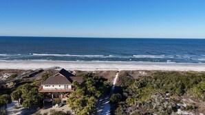 A beachfront property with a two-story house, a wooden deck, and a view of the ocean. - Beach House - Salty Dolphin (Port St. Joe)