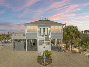 A two-story beachfront house with a balcony, a covered porch, and a small garden area. - Beach House - Salty Dolphin (Port St. Joe)