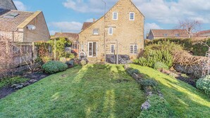 Ein Steinhaus mit gepflegtem Rasen und einem kleinen Garten.