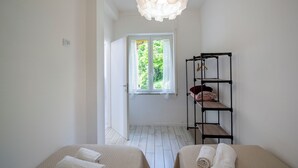 Un dormitorio con cama, armario y estante colgante.