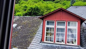 Un edificio de techo rojo con una ventana, visto desde una ventana con marco negro.