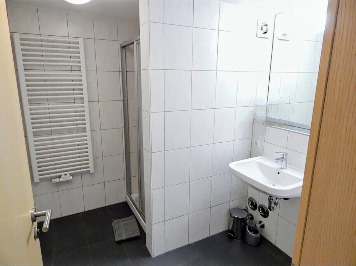 A small bathroom with a shower, a sink, and a toilet.