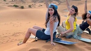 Three people sitting on a sand dune with a sunset in the background. - Merzouga Luxury Tented (Merzouga)