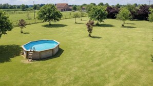 A backyard with a rectangular swimming pool, surrounded by a well-maintained lawn and trees. - Le Château de Chambois ✦ Confidential ✦ Families ✦ Seminars (Gouffern en Auge)
