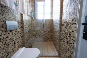 Economy tweepersoonskamer | Badkamer | Een douche, een haardroger, handdoeken, zeep