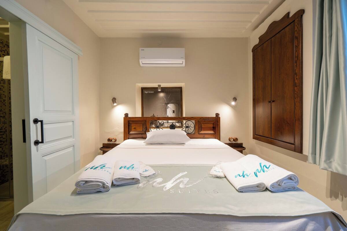Una habitación de hotel con cama, armario, equipo de aire acondicionado y un cartel sobre la puerta.