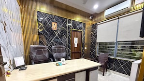 A modern office with a marble wall, two leather chairs, a wooden desk, and a window with blinds. - Dream Lounge (Jalandhar)