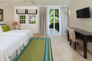 A hotel room with two beds, a desk, a television, and a sliding glass door to the outside. - Sapphire Beach 116 2 Bedroom Apts (St. Lawrence Gap)