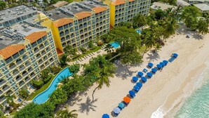 Ein Resort mit Pool, Strandliegen und einem Strand.
