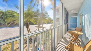 Ein Balkon mit Blick auf Palmen und einen Strand.