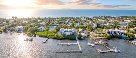 A coastal residential area with a marina, houses, and a large building with a white facade.