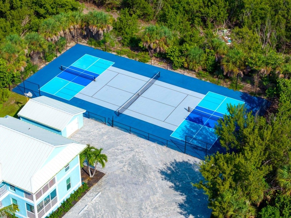 Un edificio grande y rectangular con techo plano, rodeado de abundante vegetación.