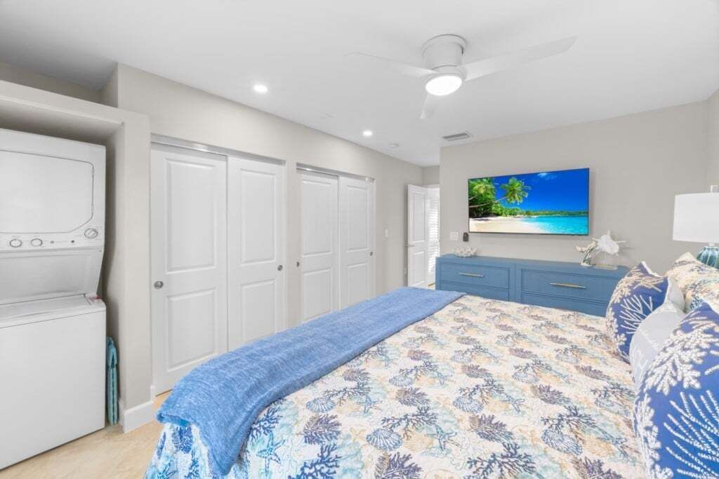 Ein Schlafzimmer mit einem Bett, einem Fernseher, einem Deckenventilator und einem Kleiderschrank.