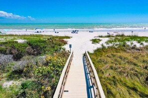 A wooden boardwalk leading to a beach with clear skies and calm waters. - Coquina 3f 3 Bedroom Condo (Sanibel)