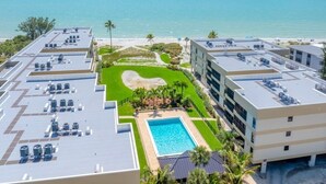 Un hôtel doté d’une piscine sur le toit, offrant une vue sur la plage et comprenant un jardin aménagé.