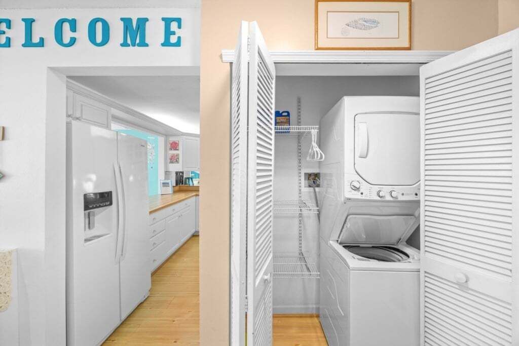 A laundry room with a washing machine and dryer, a water dispenser, and a shelf with laundry supplies.