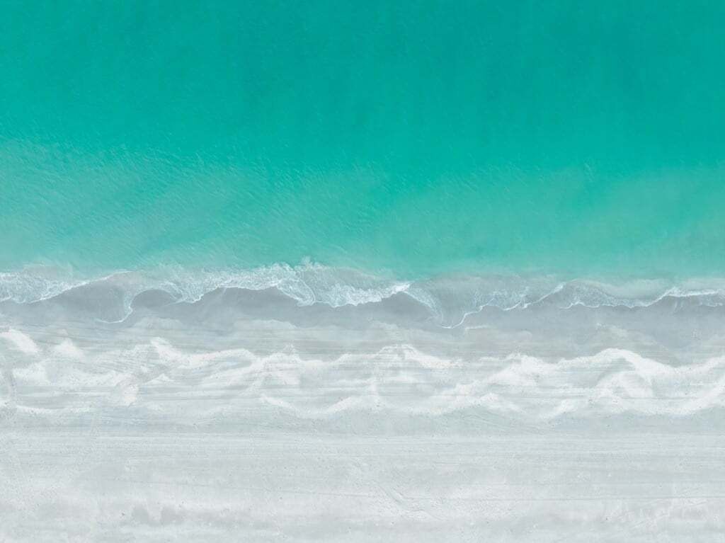 Una playa con agua turquesa y arena blanca.