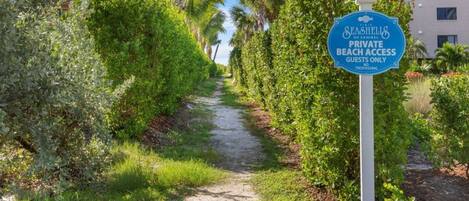 Un sentiero che conduce a un cartello di accesso privato alla spiaggia per Seashields of Sanibel, che indica l'accesso riservato agli ospiti.