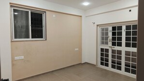 A room with a large window, a sliding glass door, and a tiled floor. - Beautiful 1-bedroom bungalow in pleasant Pune neighborhood (Pune)