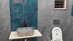 A bathroom with a marble vanity, a toilet, and a shower. - Beautiful 1-bedroom bungalow in pleasant Pune neighborhood (Pune)
