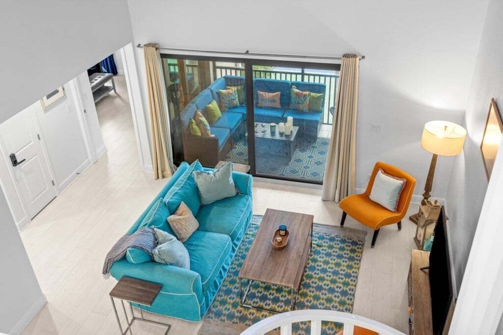 A modern living room with a blue sofa, a wooden coffee table, and a patterned rug.