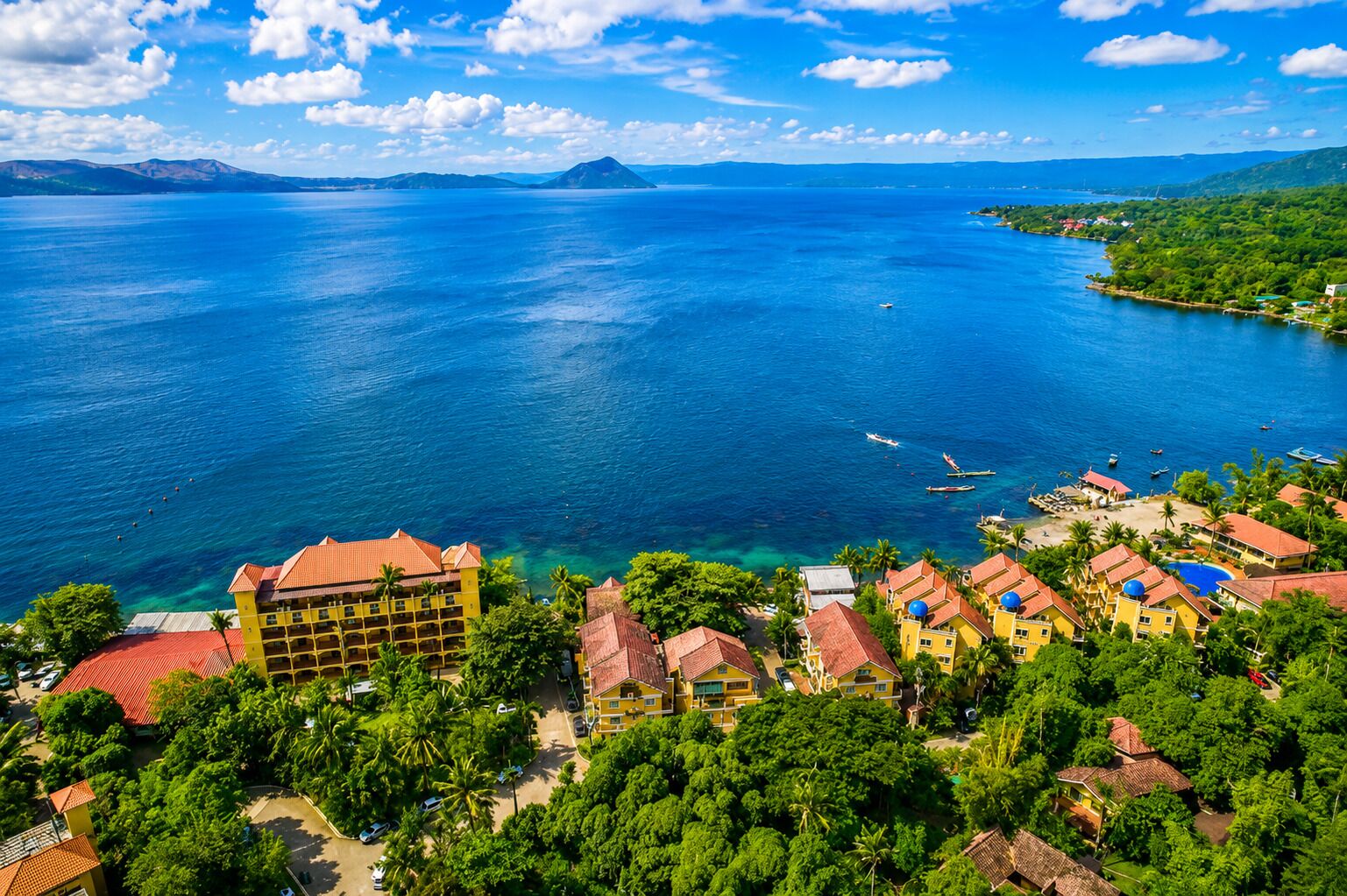 A coastal resort with multiple buildings, a marina, and a clear view of the sea.