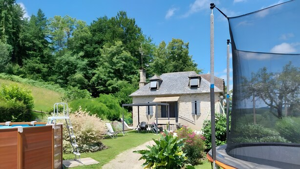 A house with a garden, a trampoline, and a wooden deck.