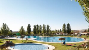 A large outdoor swimming pool with multiple lanes, surrounded by grassy areas and trees. - Bungalow with Terrace - Sleeps 2 (Humilladero)