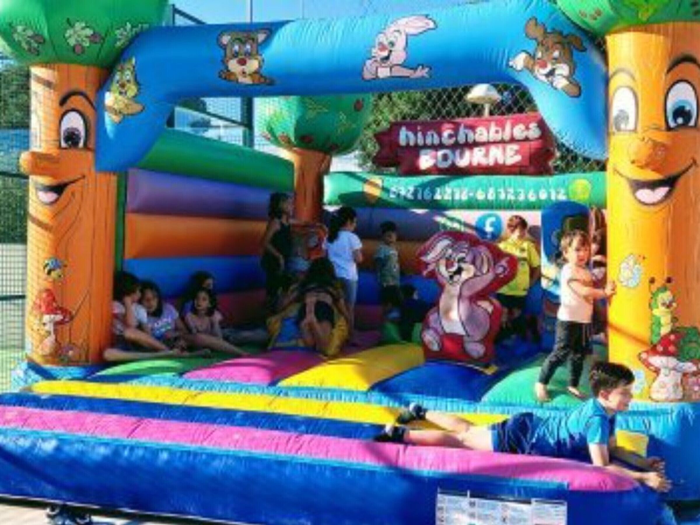 An inflatable play area with cartoon characters and a sign that reads "Hinchables BOURNE."