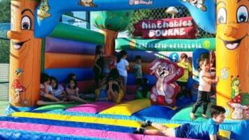 An inflatable play area with cartoon characters and a sign that reads "Hinchables BOURNE."