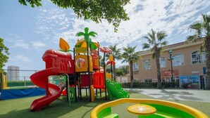 A playground with a slide, climbing structures, and a small pool. - Bungalow with Terrace and Accessible Ramp in Guardamar (Guardamar del Segura)