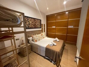 A bedroom with a bunk bed, a large wardrobe, and a painting on the wall. - Charming 18th-century home in Granada, parking included (Granada)