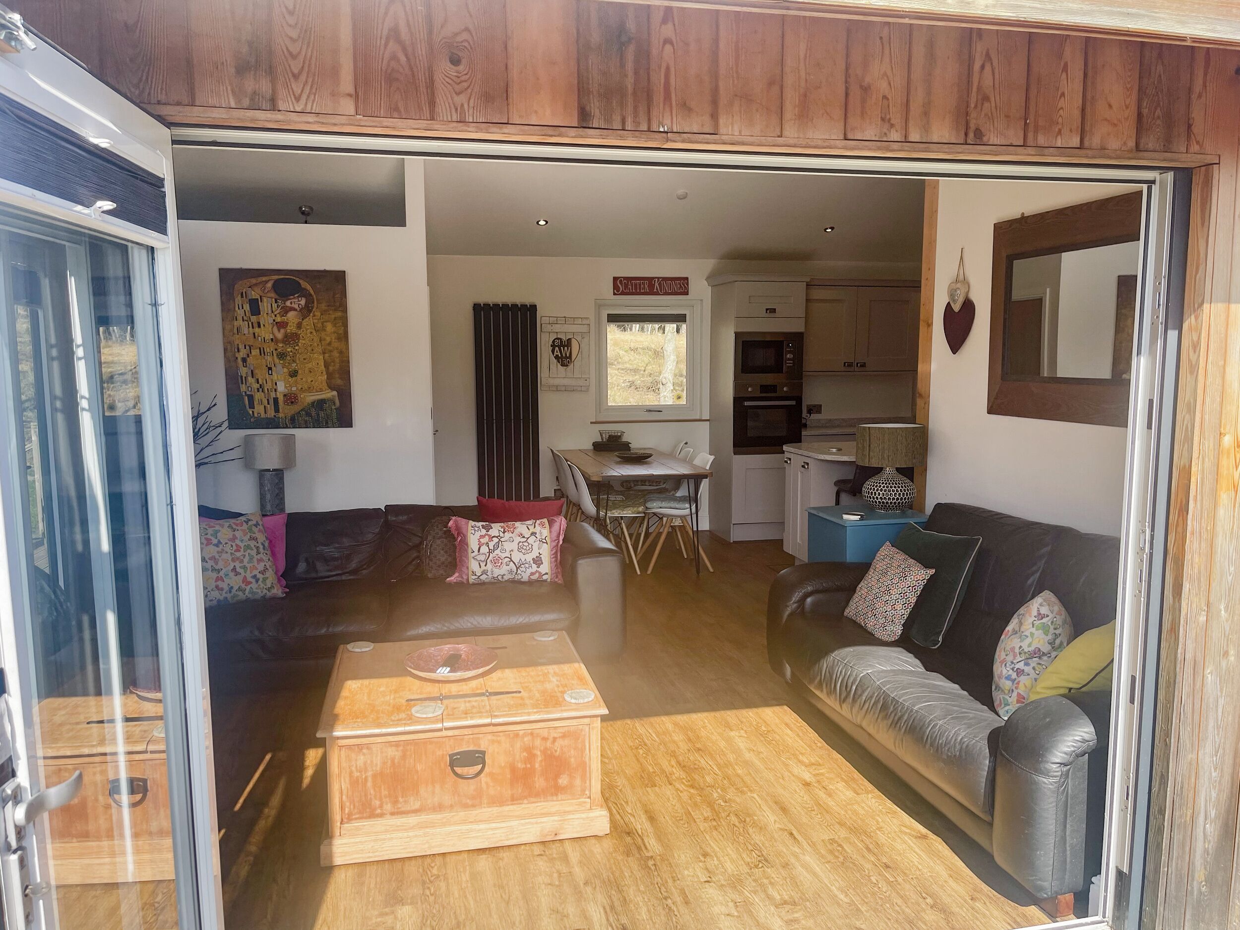 A cozy living room with a sofa, a wooden chest, and a dining area with a table and chairs.
