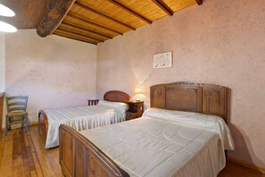 A bedroom with two beds, wooden headboards, a chair, and a nightstand with a lamp. - Holiday Home 'Le Mas' with Mountain View, Wi-Fi, Air Conditioning (Arles-sur-Tech)