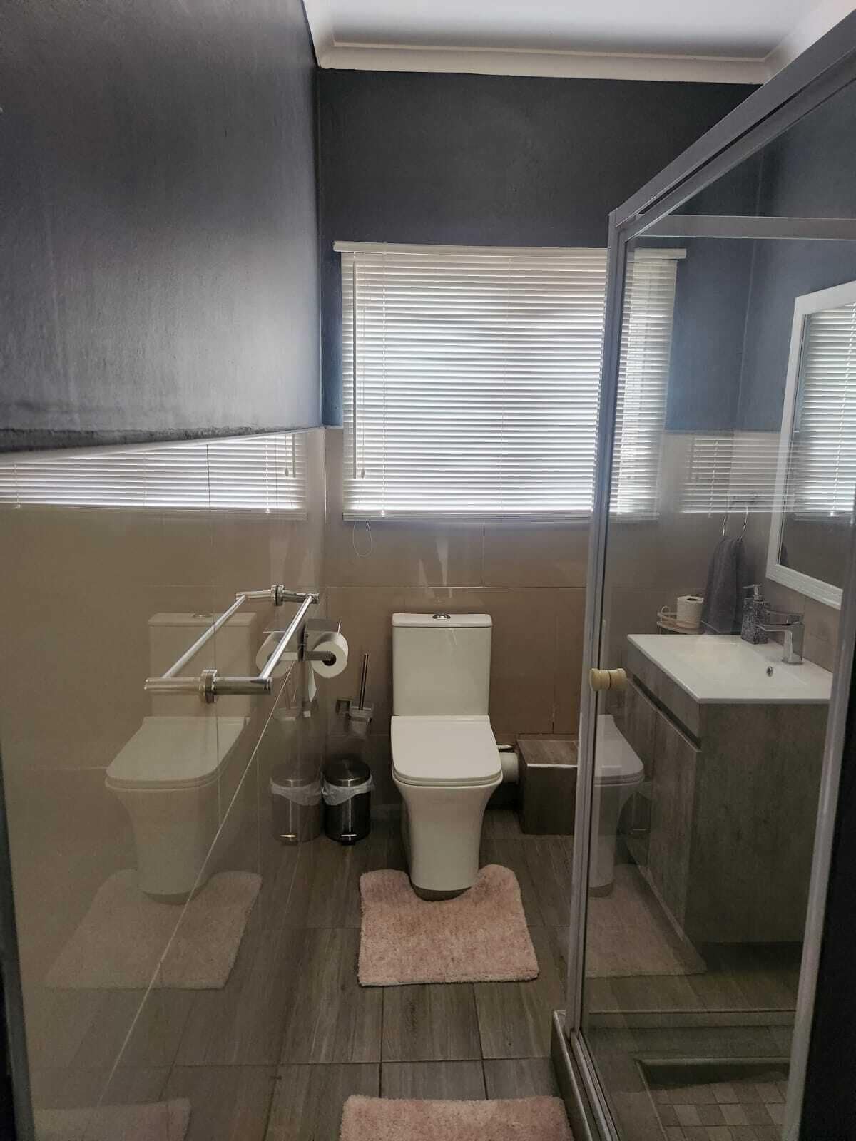 Un baño moderno con cabina de ducha de vidrio, inodoro, bidé y lavamanos.