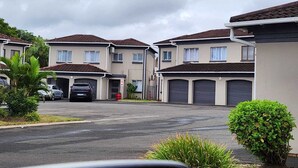 Una zona residencial con varias casas de dos pisos, cada una con su garaje.