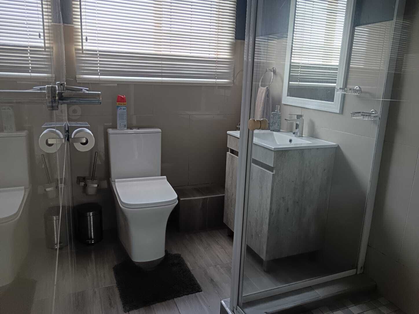 A modern bathroom with a toilet, bidet, and shower.