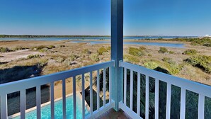 Ein Balkon mit Blick auf einen Pool und die Küstenlandschaft.