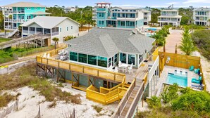 A beachfront property with a large house, a wooden deck, and a swimming pool. - Beachfront House - Casa Bella Del Sol (Port St. Joe)