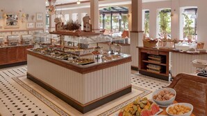 A buffet area with various food items and a central serving station. - Sunday Resort Rugen 1-bedroom Apartment (Sagard)