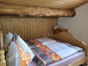 A wooden bunk bed with a patterned bedspread and pillows. - Alpe Monte Massella by Interhome (Poschiavo)