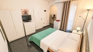 A hotel room with a bed, a desk, a TV, a kitchenette, and a bathroom. - Ein Apartment im Ferienhaus Zweirosen by Interhome (Fažana)